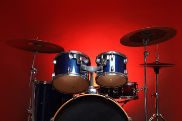 Obraz premium Drum kit on red gradient background, low angle view. Musical instruments
