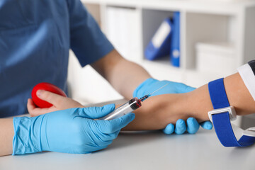 Obraz premium Nurse drawing little boy's blood sample in clinic, closeup