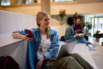 Obraz premium Happy female student using wireless technology at university.