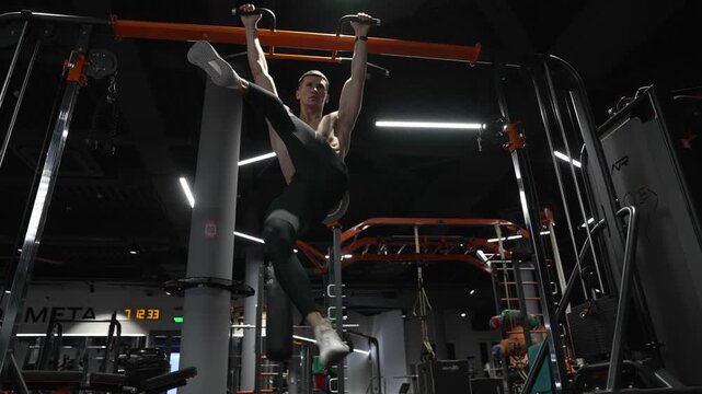 Muscular sportsman do abs workout. Lifting legs. Exercise for abs sixpack torso muscle. Hanging leg raises or man in training. Sporty man training abs. Sixpack exercise by hanging leg raises, 4k