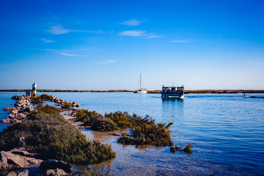 Boat sailing in fuseta lagoon algarve peaceful coastal landscape