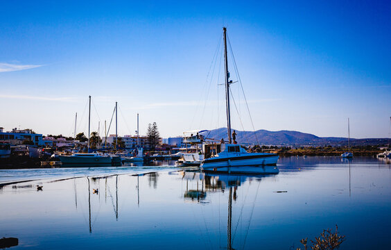 sailboat in fuseta harbor algarve calm coastal landscape reflection