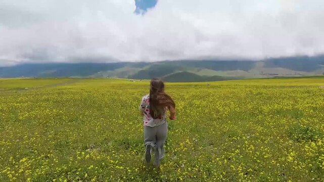 mujer pelo largo corre en monta&ntilde;a con flores amarillas