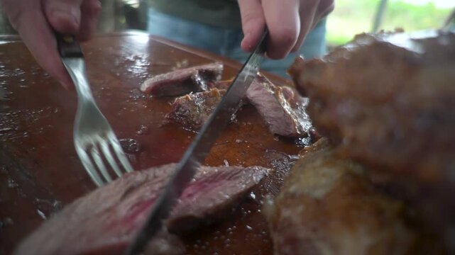 persona sirve carne asada en tabla de madera