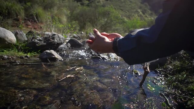 persona lava sus manos en el rio