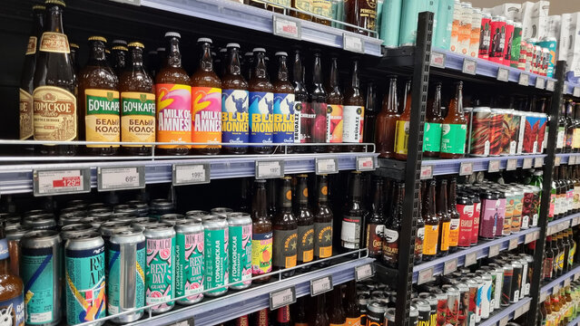 Craft beer bottles and cans on supermarket shelves beverage aisle