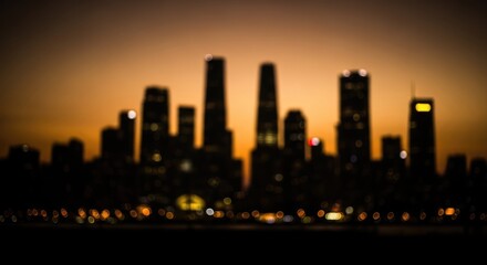 Obraz premium Blurred Silhouette of City Skyline at Sunset with Warm Orange Glow.