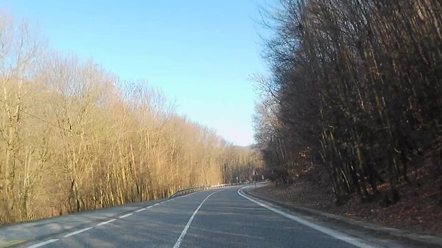 Road ride video on mountain pass of Pezinska Baba, western Slovaka, between town of Pezinok and village of Pernek, during dry winter season, february 2026. Naked broadleaf trees visible around.