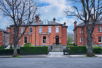 Row of large brick semi-detached houses in an older suburban residential neighborhood