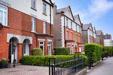 Row of large brick semi-detached houses in an older suburban residential neighborhood