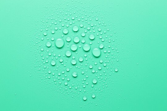 Many water drops on green background, top view