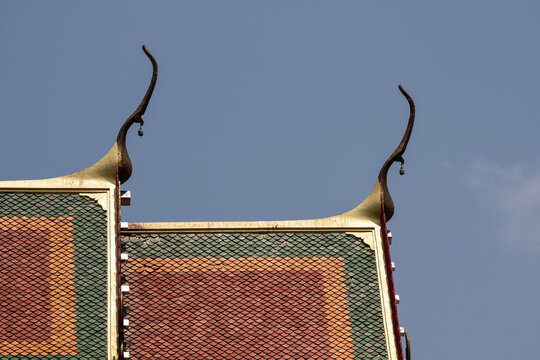 Thai Temple Roof Detail with Golden Chofah and Traditional Tiles.