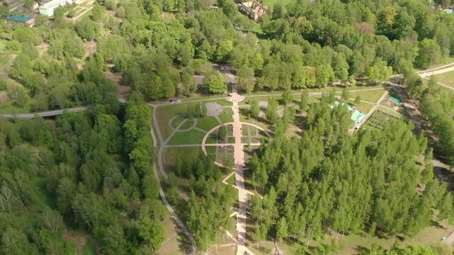 Ascending aerial retreat above green park in Klin