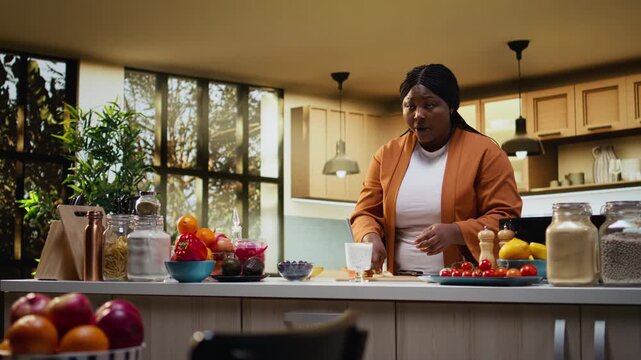 Black food vlogger making chia bowl with yogurt in home kitchen studio, female influencer filming healthy breakfast choice idea with tutorial vlog for online social media channel.