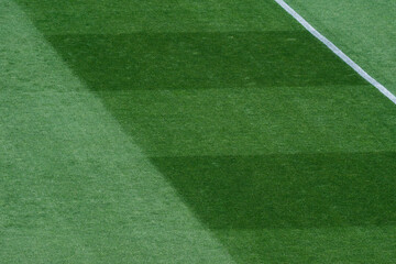 Obraz premium Background Texture of International-Standard Football Pitch with Striped Grass and Field Lines Under Clear Conditions