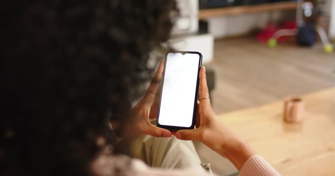 Nonbinary person holding phone with blank screen at home as shifting grip awaiting screen update