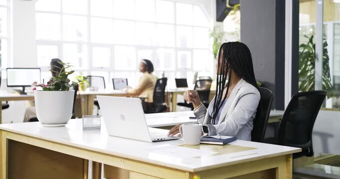 Diverse coworkers working on laptop at desk after Indian woman approaches colleague requesting data