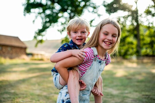 Joyful siblings playing outdoors.