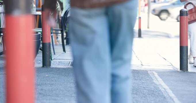 Person entering from right is walking past planter between bollards, other people heading to street