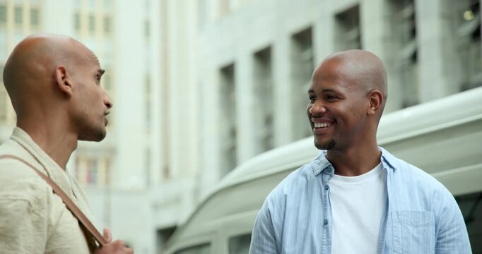 Two African American men laughing and responding to joke, catching up on city street beside van