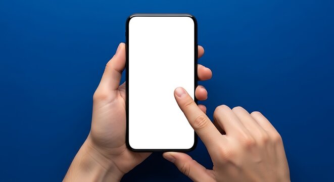 Close-up of hands holding modern smartphone with blank white screen, fingers touching display, isolated on vibrant blue background, studio shot