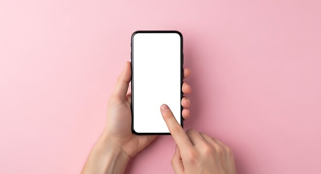 Closeup of a person's hands holding and touching a modern smartphone with a blank white screen on a pastel pink background, top-down studio shot.