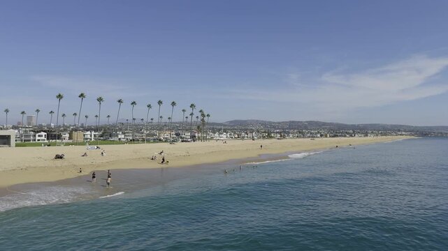A wide shot of people on Newport Beach playing in the water, Newport Beach, CA