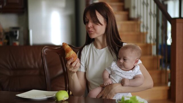 Young mother with a newborn baby in her arms makes a choice between a healthy apple and an unhealthy croissant, eventually choosing the pastry