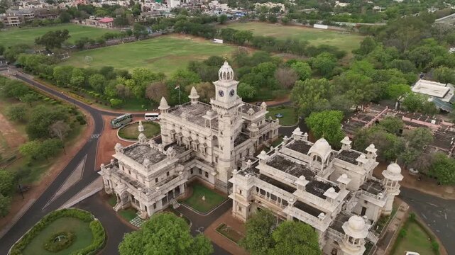 Mayo college boarding school heritage building surrounded by garden and Aravalli hills under rainy sky, revealing drone shot