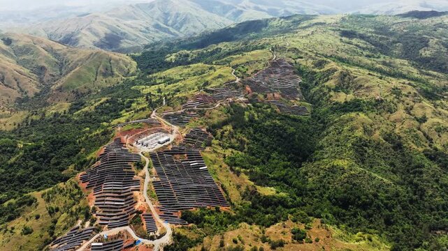 Green energy infrastructure and solar panels covering mountain valley landscape