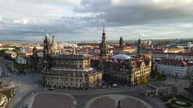 Drone flies over the bridge and arcs around the Semperoper in evening light.