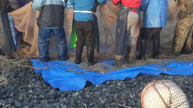 海岸から網を引く漁師