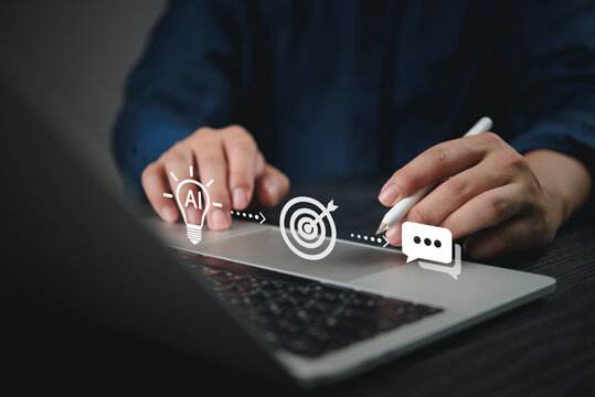 Businessman hand using laptop stylus pen artificial intelligence AI icon target audience marketing strategy chatbot communication digital technology futuristic smart automation online business.