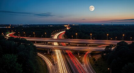 Fototapeta premium Nighttime Freeway Interchange Bathed In Moonlight With Light Streaks