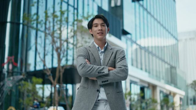 Portrait of business men in grey suit standing with arms crossed outdoor in city urban office building background.Concept of professional leadership,successful lifestyle and confident executive.
