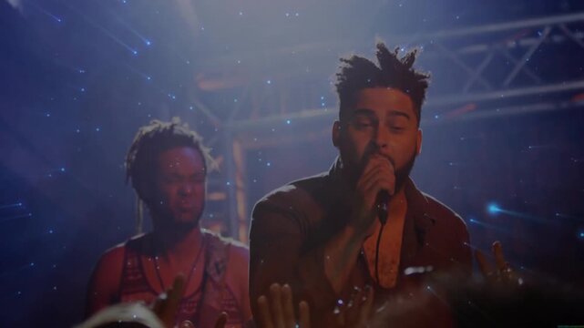 Hands reaching, lead singer with mic, singing in concert, blue flares sweeping past, engaging crowd