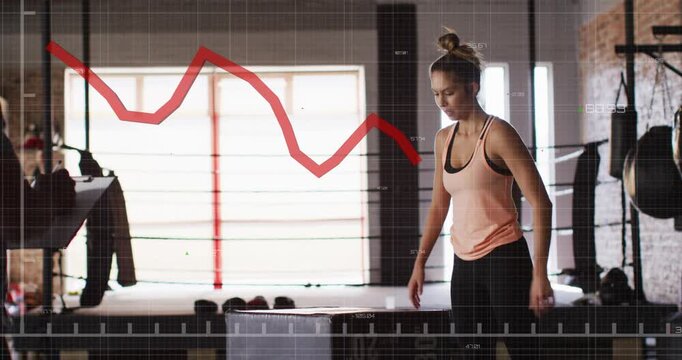 Female athlete wrapping wrists squatting and jumping box red graph tracking fitness coach recording