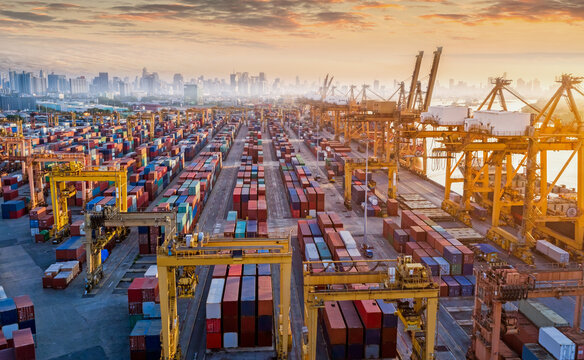 Logistics and transportation of Container Cargo ship and Cargo plane with working crane bridge in shipyard at sunrise, logistic import export and transport industry background