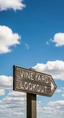 Obraz premium Rustic Vineyard Lookout Sign Points To Scenic Destination Under Expansive Blue Sky