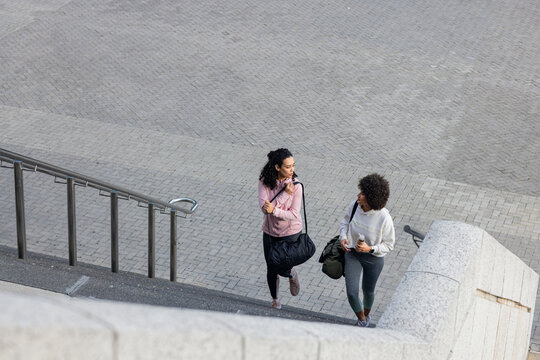 Interlocking pavers covering urban plaza and leading up to stone staircase, steel handrail