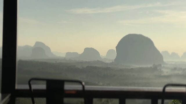 Sunrise light over misty limestone formations at Din Daeng Doi in Krabi Thailand creating soft layered landscape with calm horizon and scenic natural beauty