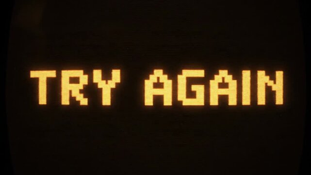 A pixelated orange 'try again' message glows on a dark screen, symbolizing resilience after bankruptcy.