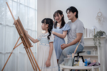 Obraz premium Asian Family painting together at home, parents teaching daughter art and creativity activity.