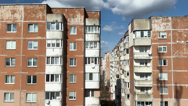 Old Soviet apartment buildings under a blue sky, the dilapidated facade of a residential complex