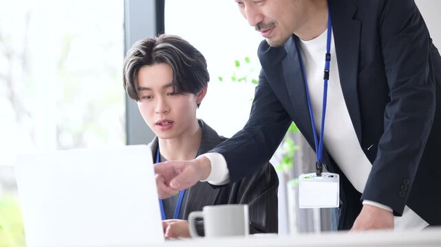 会社の仕事中に上司に励まされる新卒などの新入社員の爽やかなイメージ　その調子！仕事頑張ってね！OJTで先輩に指導を受ける若手社員の成長と教育のビジネスシーンの動画