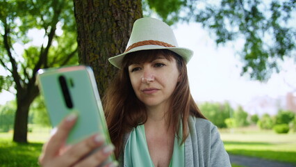 Fototapeta premium Young Woman Using Smartphone Outdoors in Park, have fun and enjoy