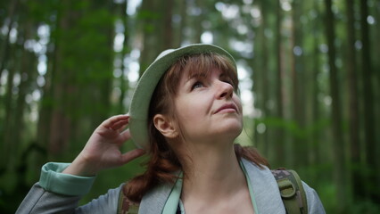 Fototapeta premium Young Woman Hiking in Forest Wearing Backpack and Hat, have fun and enjoy