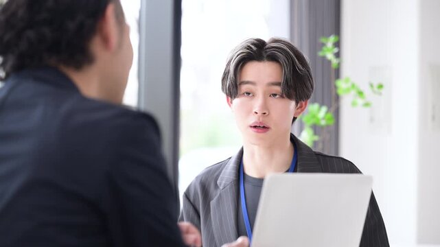 仕事での面談やキャリアカウンセリングなど対面で面接する爽やかなビジネスイメージ　デザイナーやエンジニア、マーケターなどクリエイティブ職のインターンなど新卒の若い男性の動画