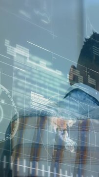 Vertical video: Seated man watching standing child reading, HUD charts animating to aid education