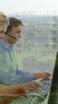 Vertical video: Male call agent adjusting headset, typing, hearing incoming call, window reflecting